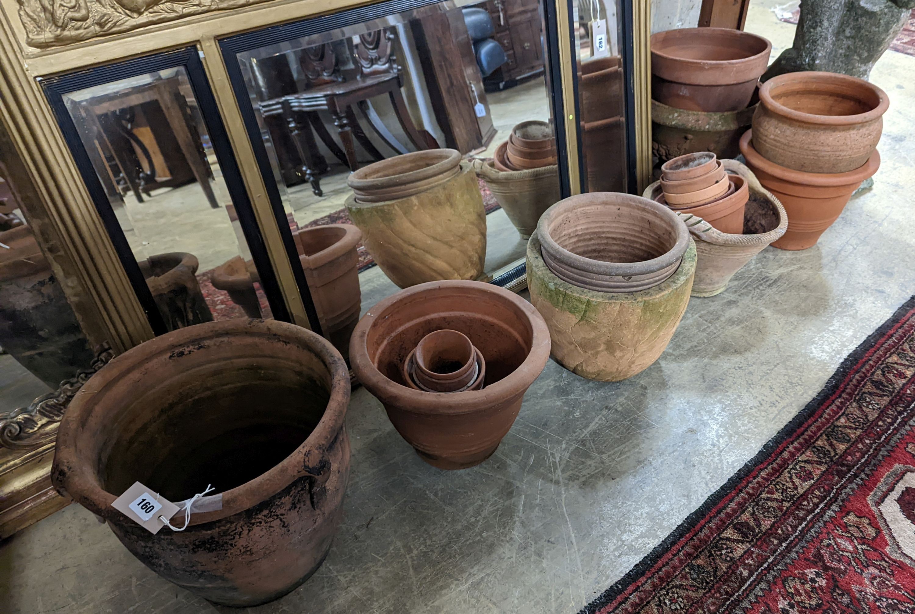 A collection of approximately 20 assorted terracotta garden planters, largest diameter 35cm